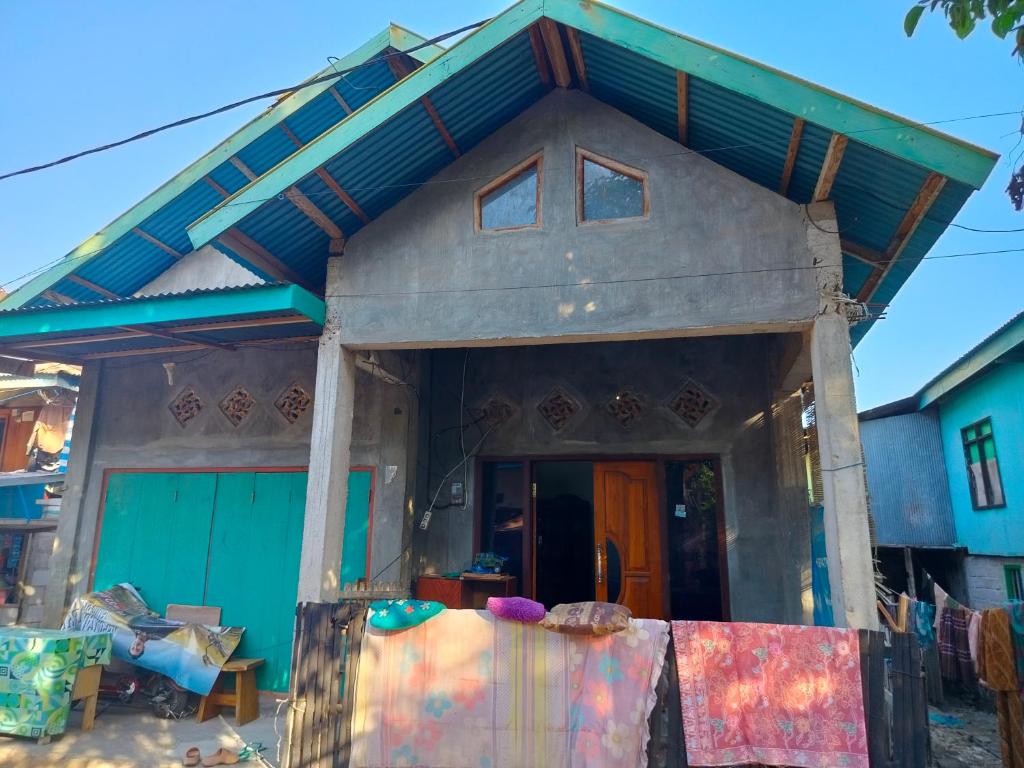 uma pequena casa com um verde e azul em Atta Ratu Homestay em Komodo