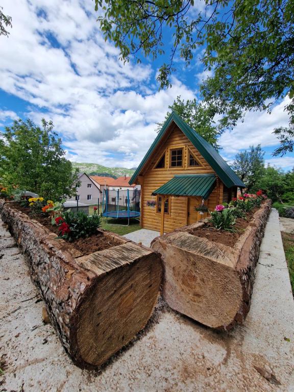 drewniany domek z kwiatami przed nim w obiekcie Brvnara RIĆKI w mieście Cetynia