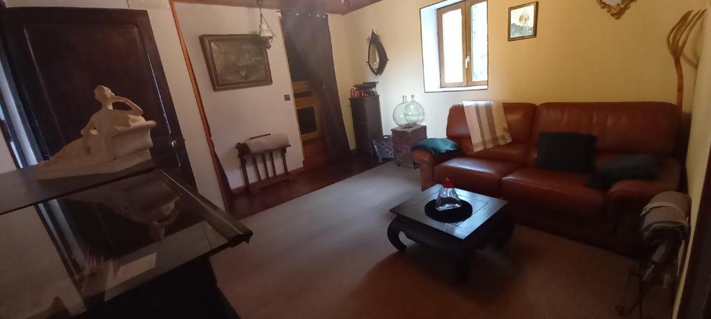 sala de estar con sofá y mesa en La croix des Landes gîte ou chambre d'hôte avec piscine à Chouvigny, en Chouvigny