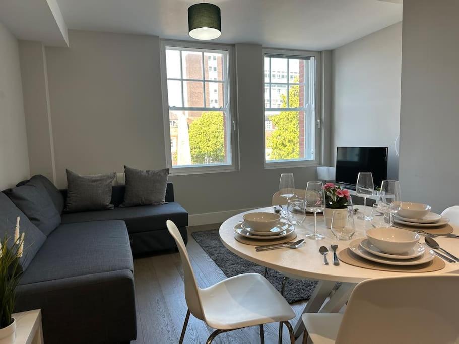 een woonkamer met een tafel en een bank bij Bright, spacious 1 bedroom flat in Brentwood