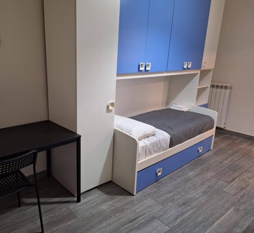Cette petite chambre comprend un lit et des armoires bleues. dans l'établissement MBR-Napoli, à Naples