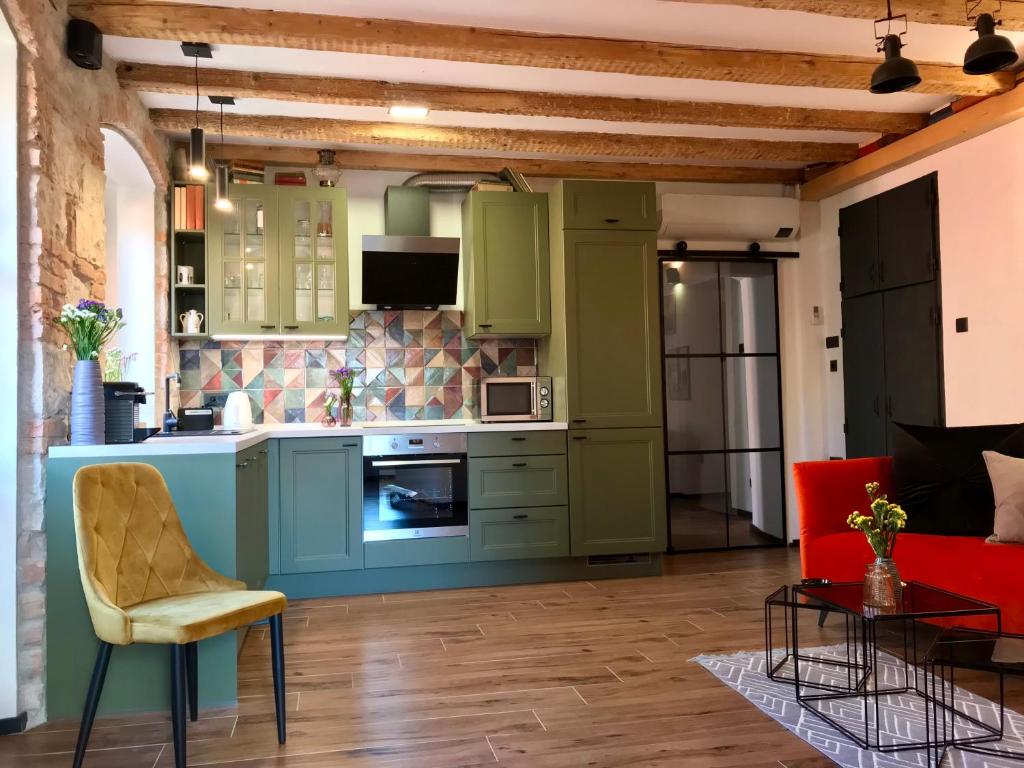 eine Küche mit grünen Schränken und einer roten Couch in der Unterkunft Split Centar Diocletian's Palace in Split