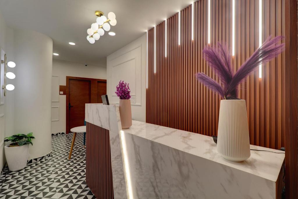 a lobby with a reception desk with purple flowers at Hotel Aura Dombivali in Dive