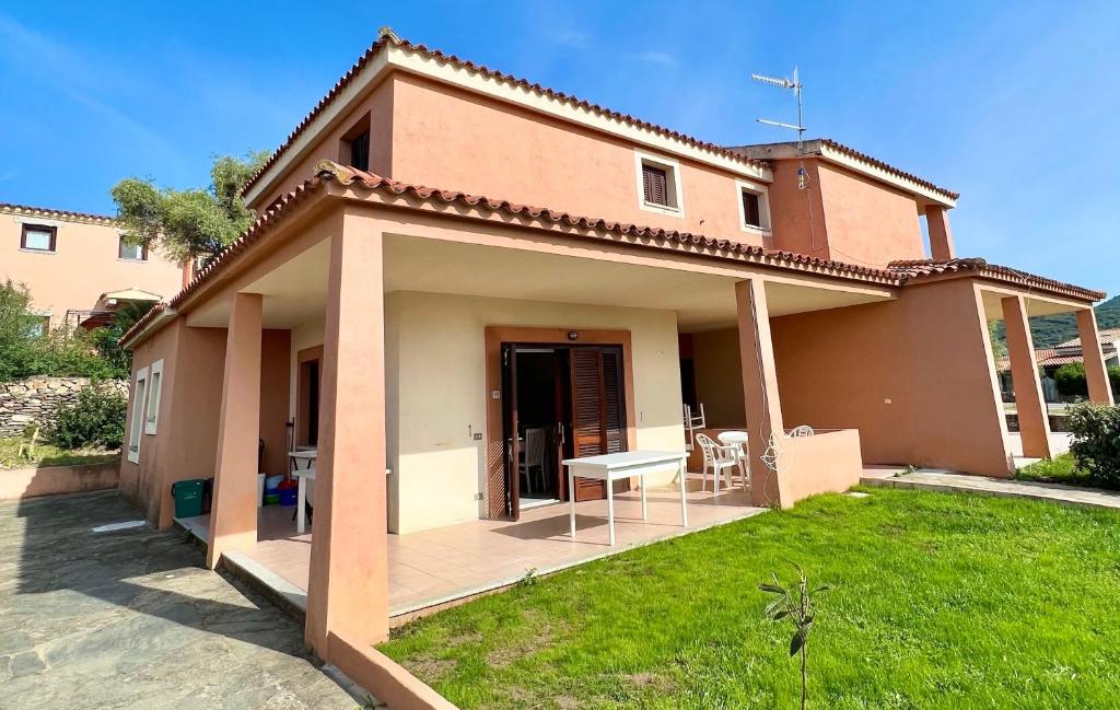 ein Haus mit einer Terrasse und einem Tisch im Hof in der Unterkunft ISS Travel, Gli Asfodeli - Large apartments with private terrace in San Teodoro