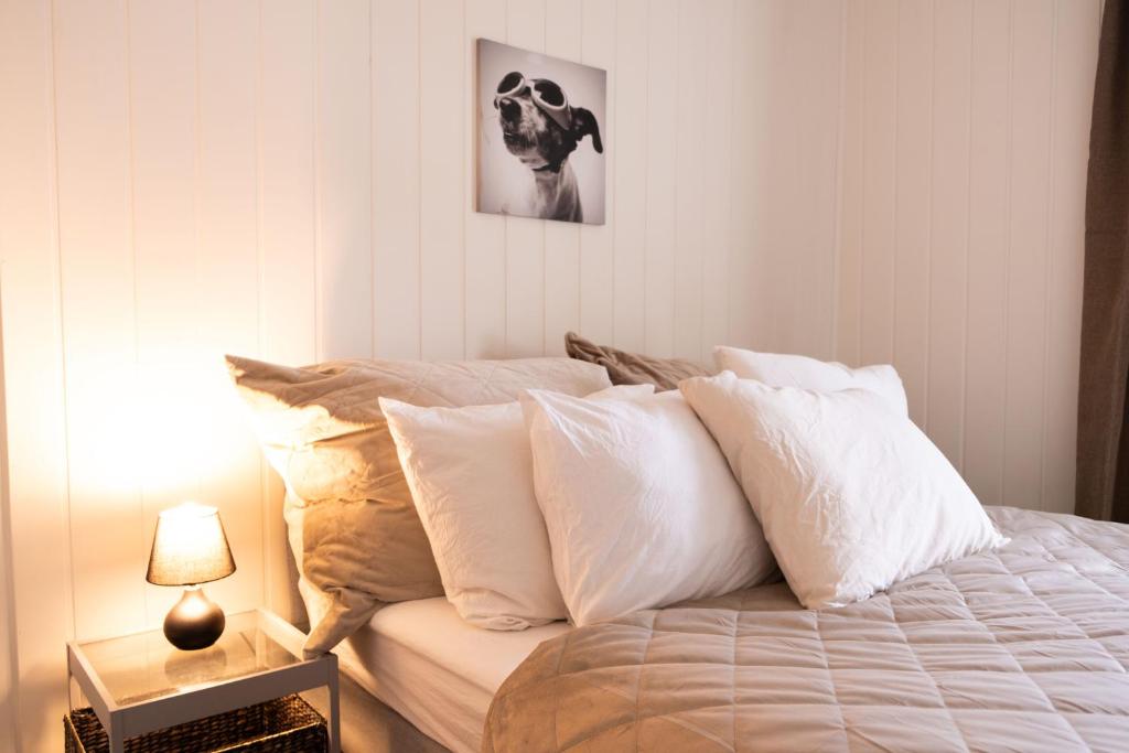 1 dormitorio con 1 cama con almohadas blancas en 5 mins to City center in Bright & Cozy stay, en Trondheim