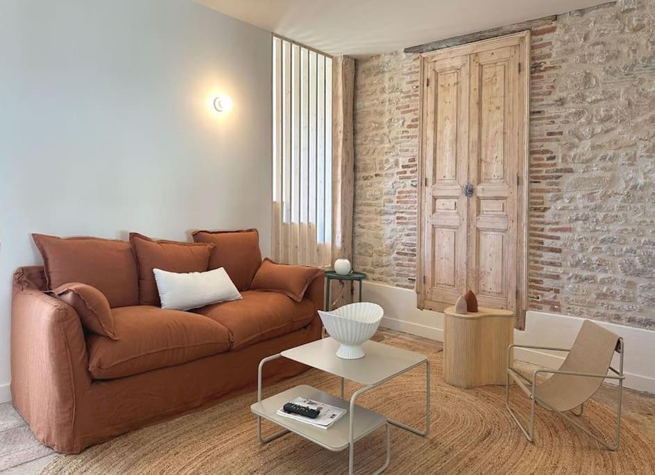 un salon avec un canapé marron et une table dans l'établissement La slow home, à Beaune