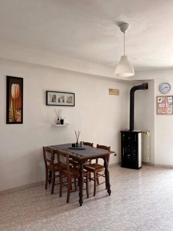a dining room with a table and chairs and a stove at Appartamento “BellaVista” a Norma in Norma