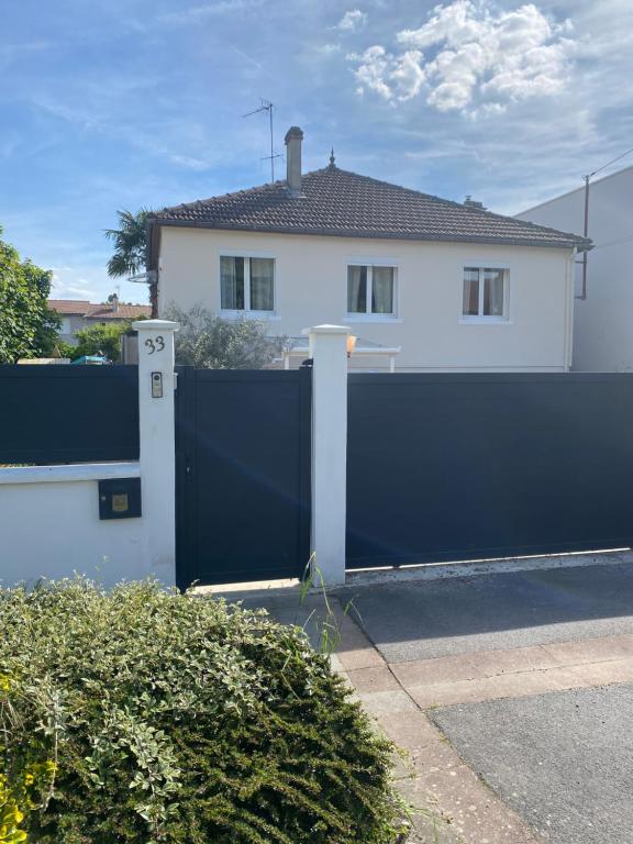 une clôture bleue devant une maison dans l'établissement appart studio RDC de maison avec extérieur proche Reims, à Tinqueux