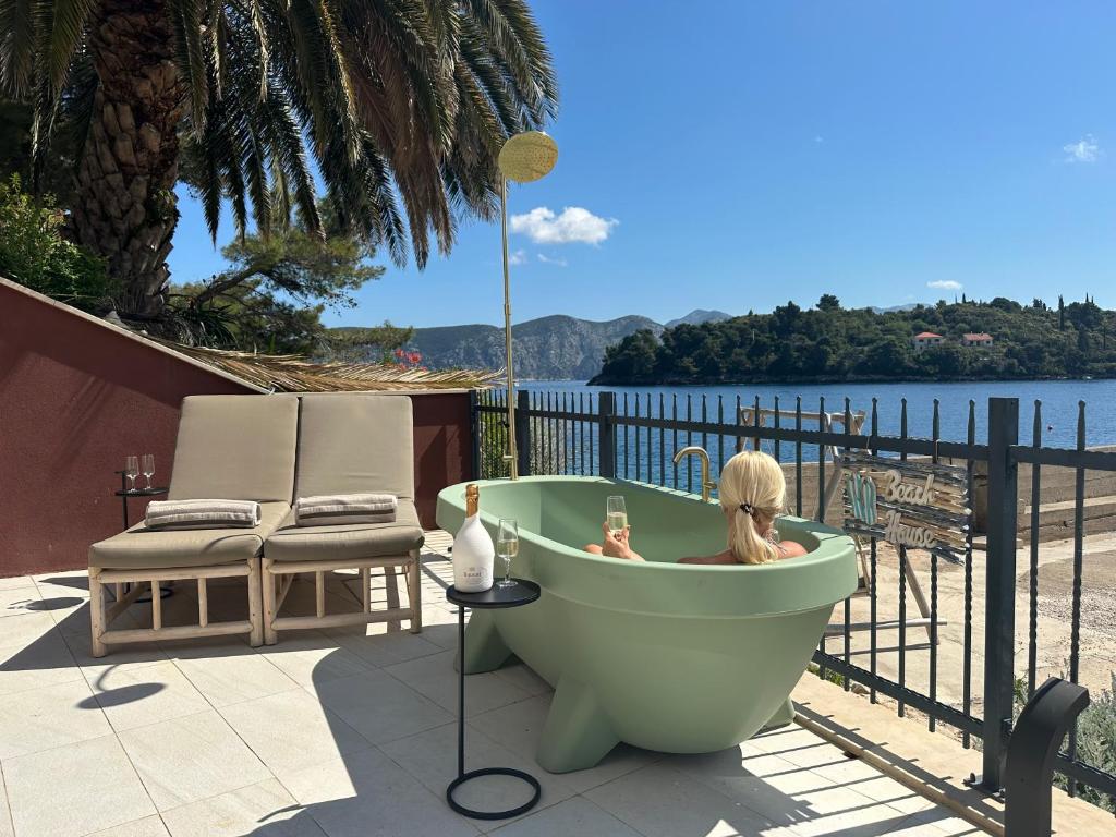 eine Frau sitzt in einer Badewanne auf einer Terrasse in der Unterkunft SeaZen Luxury Seaside Apartment Korcula in Račišće