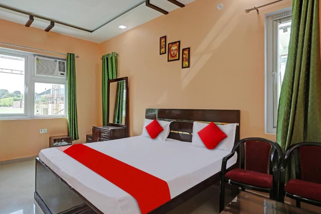 a bedroom with a bed and two chairs at OYO Flagship Mb Garden & Resorts in Lucknow