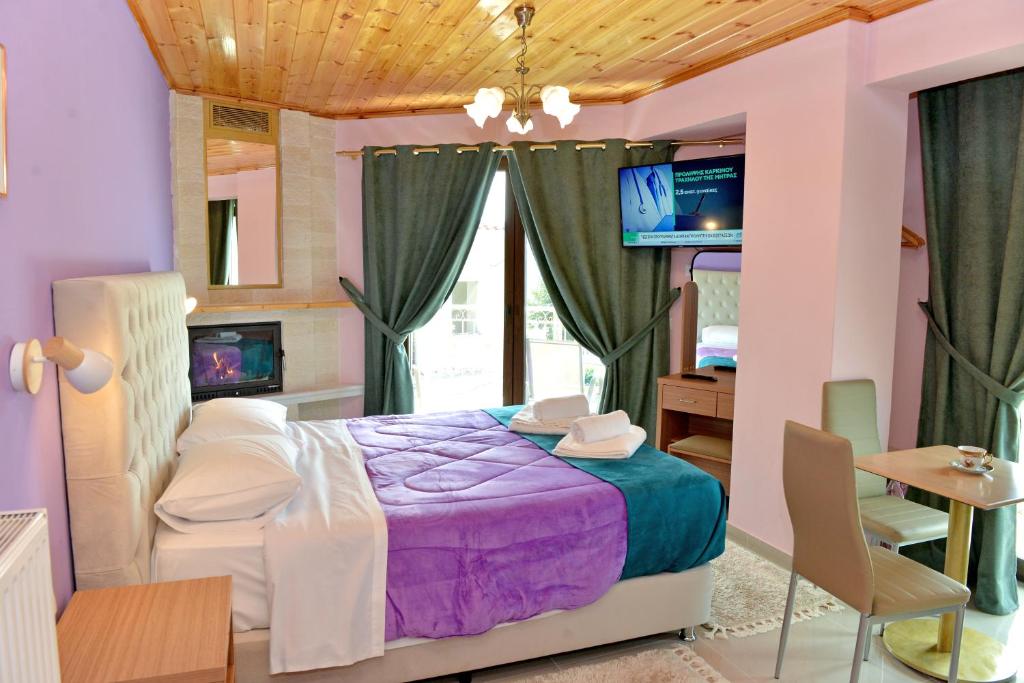 1 Schlafzimmer mit einem lila Bett und einem TV in der Unterkunft TOKASTRO 1 in Arachova
