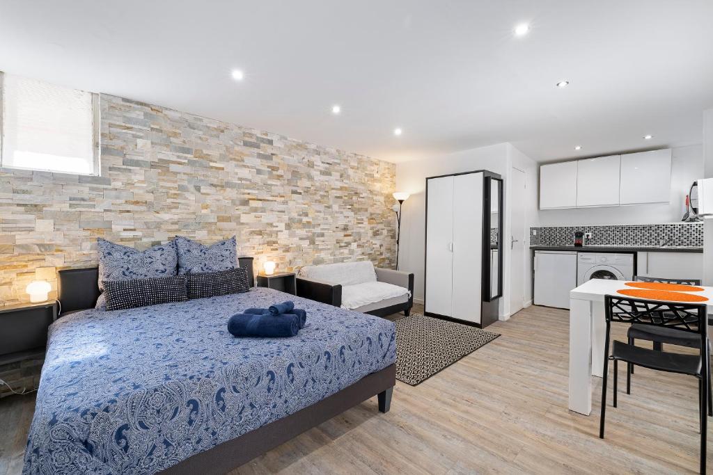 1 dormitorio con 1 cama azul y cocina en Nice Renting - PENCHIENATTI - Cosy Loft Industrial Style, en Niza
