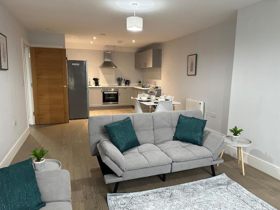 a living room with a couch and a kitchen at Spacious, bright, modern flat in Brentwood