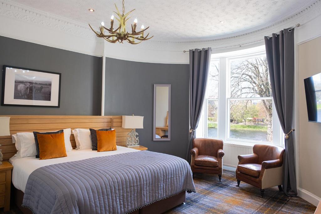 a bedroom with a bed and a chair and a window at Glen Mhor Hotel in Inverness