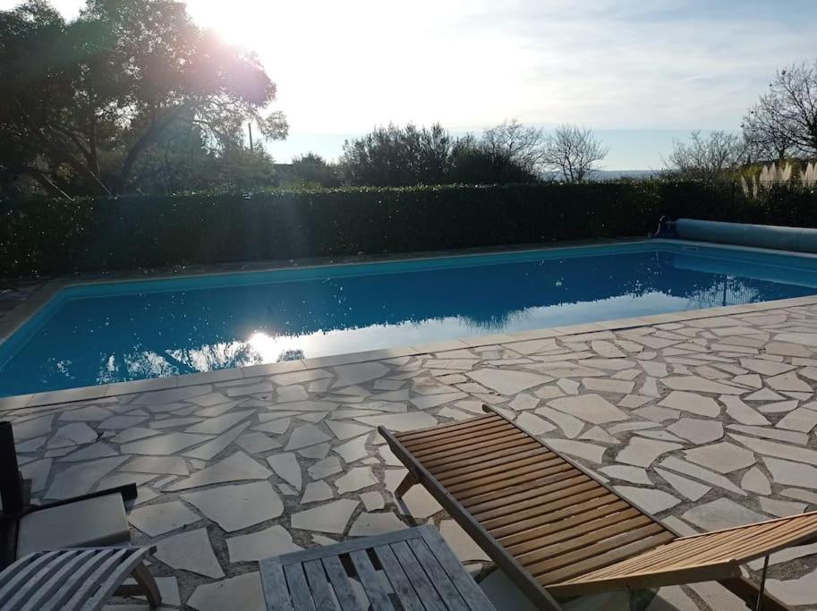 - une piscine avec 2 chaises et un banc dans l'établissement Maison provençale Verdon, à Aups