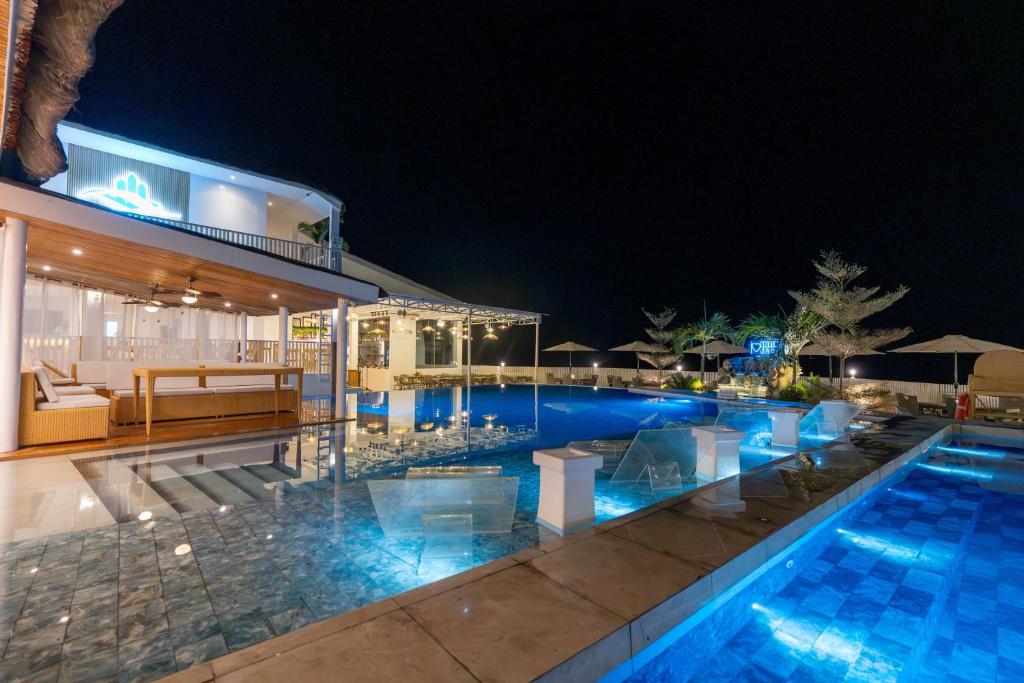 - une piscine avec une maison la nuit dans l'établissement Serene Oasis Resort - Oslob Cebu Philippines, à Oslob