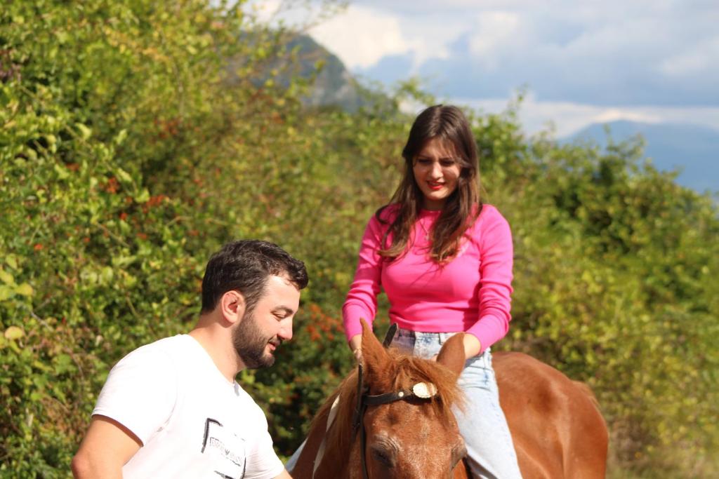 a woman riding a horse next to a man at Racha Art House in Pirveli-Tola
