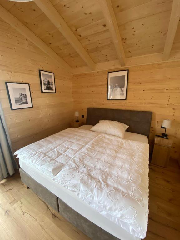 ein Schlafzimmer mit einem Bett in einer Holzhütte in der Unterkunft Naturparadies Pressegger See - Nassfeld - Weissensee in Hermagor