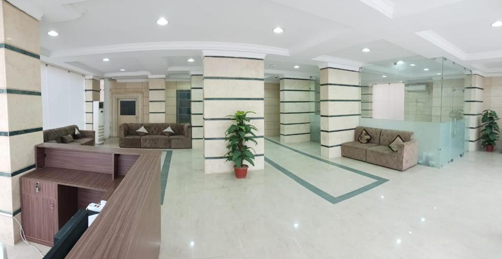 a lobby with couches and plants in a building at ماجيك سويت الرقعى Magic Suite AlRaggi in Kuwait