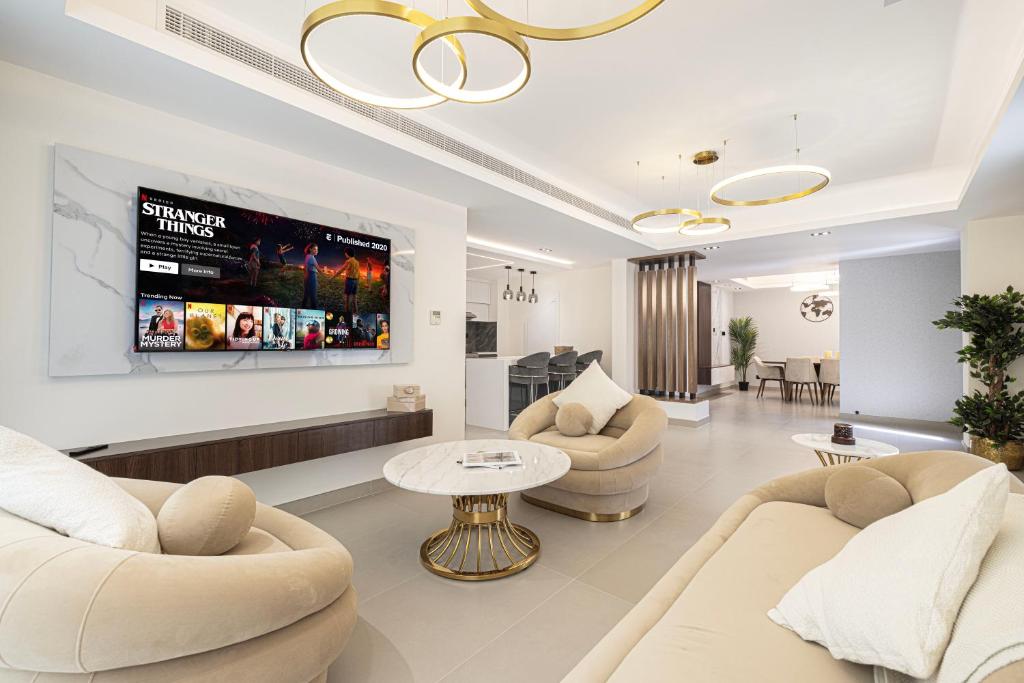 sala de estar con 2 sofás y TV en Luxurious Villa, Private Pool and Garden, Dubai, en Dubái