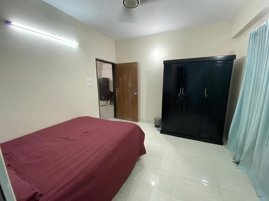 um quarto com uma cama e um armário em Service Apartment em Dhaka