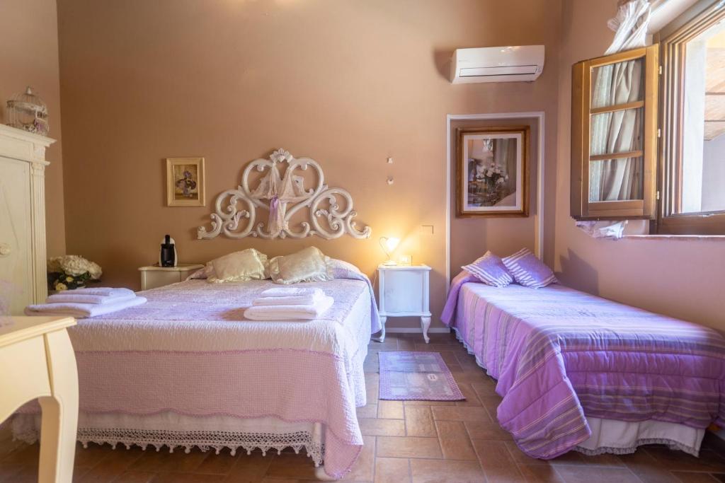 2 camas en una habitación con sábanas rosas y moradas en White Room, en Empoli