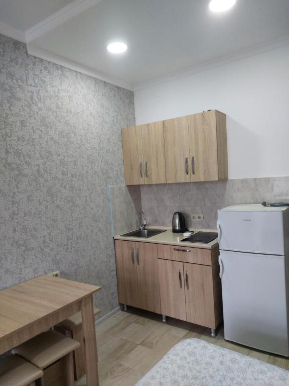 kuchnia z białą lodówką i drewnianymi szafkami w obiekcie Apartment Vesta w Kobuleti