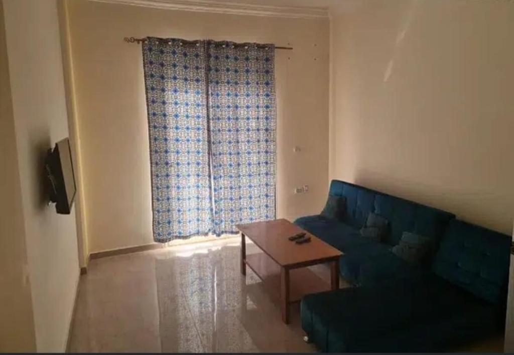 a living room with a blue couch and a table at الحي الاول 6 اكتوبر مجاورة 3 in 6th Of October