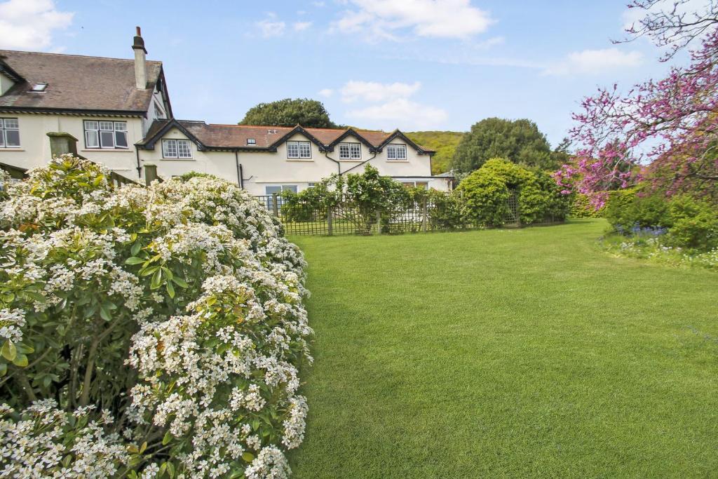 a large house with a yard with flowers at Vale View Apartment in Porlock