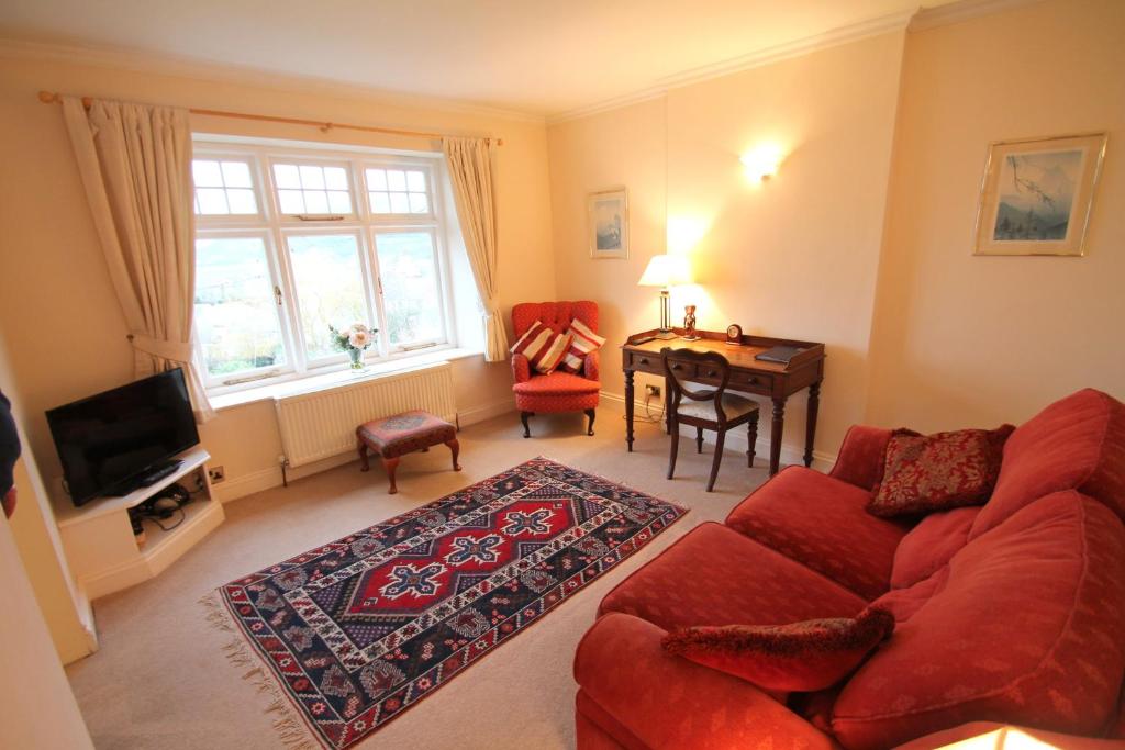 uma sala de estar com um sofá vermelho e uma mesa em Hurlestone Apartment em Porlock