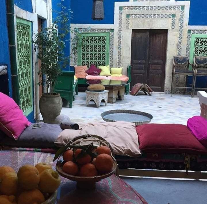 a room with two beds and a bowl of fruit on a table at Tiziri in Sousse