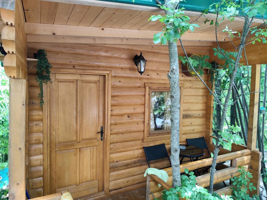 Cabaña de madera con 2 sillas y puerta en Still cabin en Cetinje