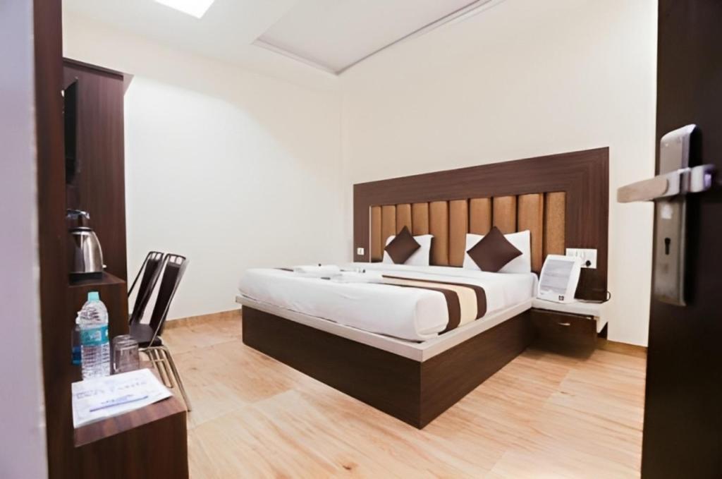 una camera con un grande letto con testiera in legno di Hotel Nirmala palace ayodhya Near Shri Ram Janmabhoomi 600m a Ayodhya