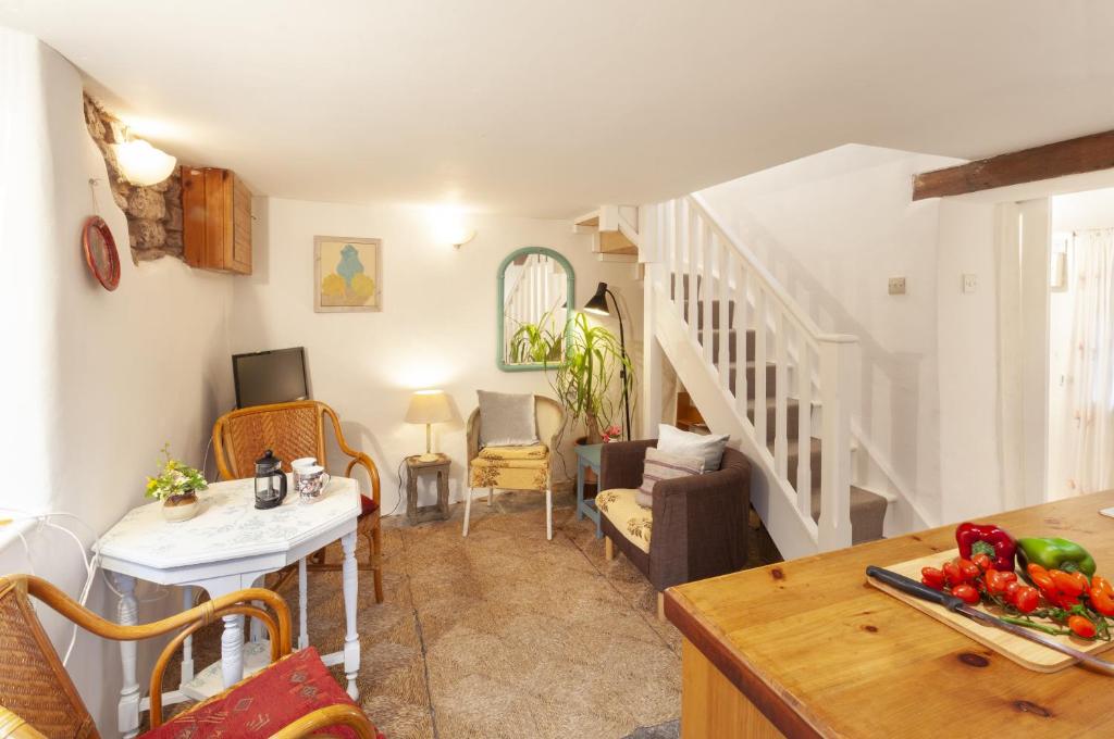 - un salon avec un escalier et une table avec des légumes dans l'établissement Garden Cottage, Wiveliscombe, à Wiveliscombe