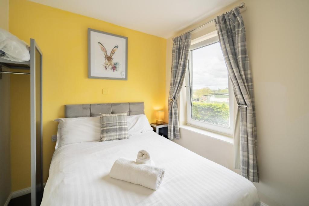 1 dormitorio con 1 cama blanca grande y ventana en The Well Inn, en Shepton Mallet