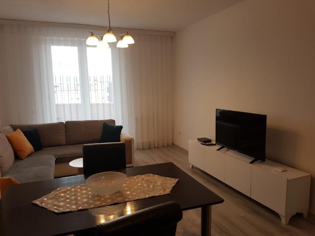 uma sala de estar com um sofá e uma televisão em Banesa ne FushKosovë em Pristina