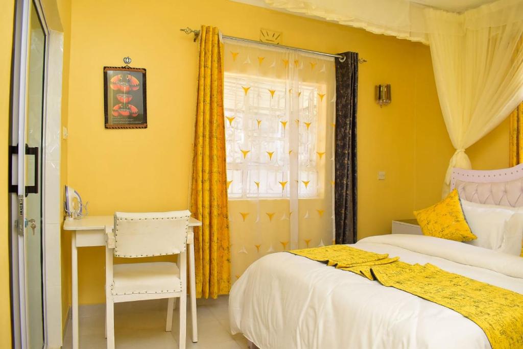 a bedroom with two beds and a desk and a window at Aggie's BnB in Nakuru