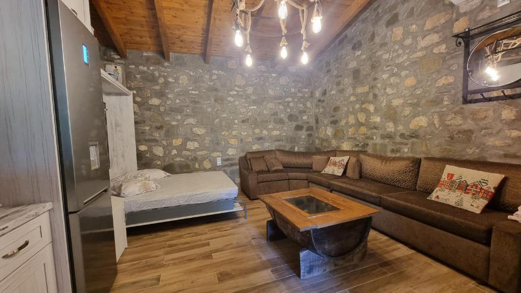 ein Wohnzimmer mit einem Sofa und einem Tisch in der Unterkunft House with big garden and barbeque in nature in Potamiá