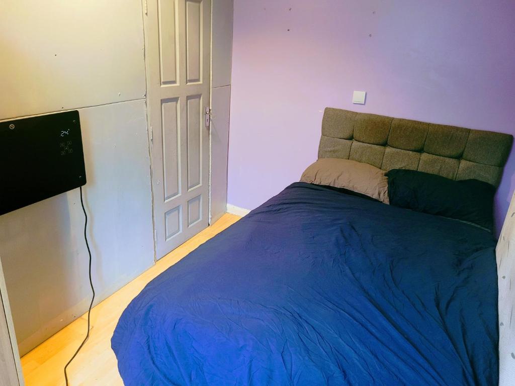 um quarto com uma cama com um edredão azul em Cosy stay em Birmingham