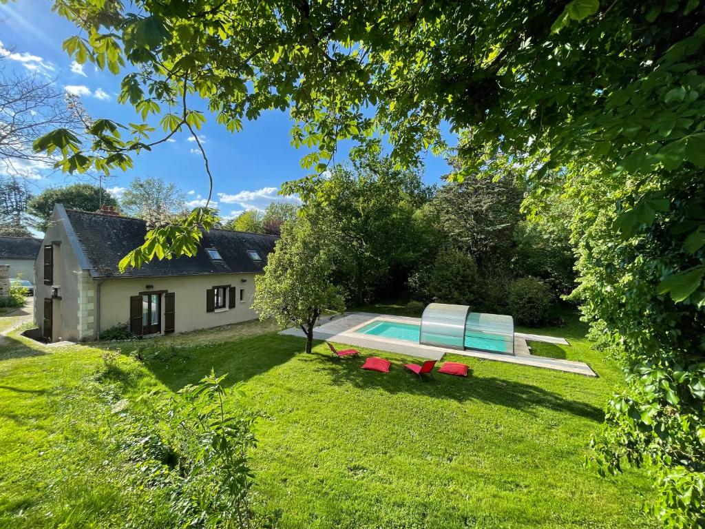 una casa con piscina en el patio en Gite du Domaine Jeanne de Laval, en La Bohalle