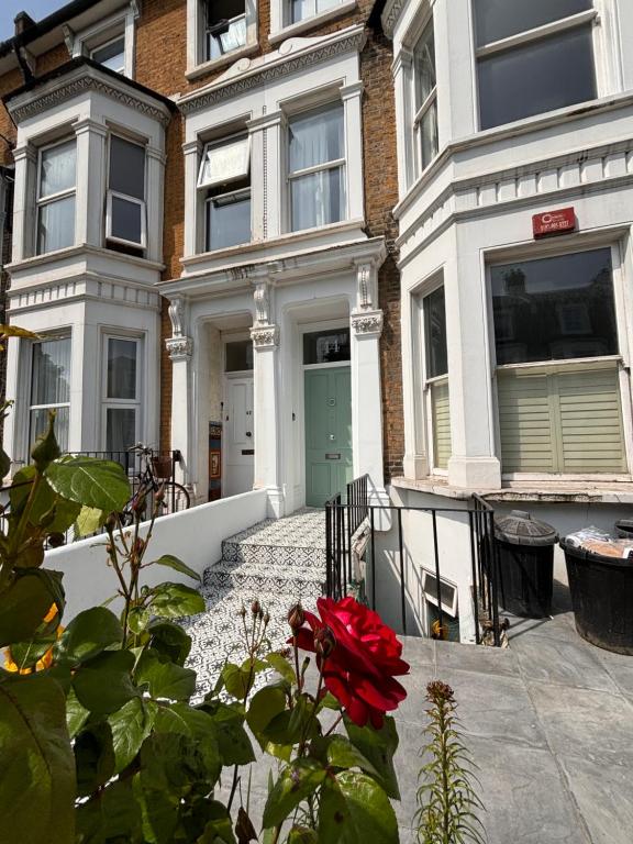 倫敦的住宿－Studio Pillo Hammersmith，前面有红玫瑰的房子