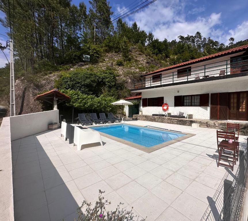 a swimming pool in front of a building at Casa dos Avós in Geres