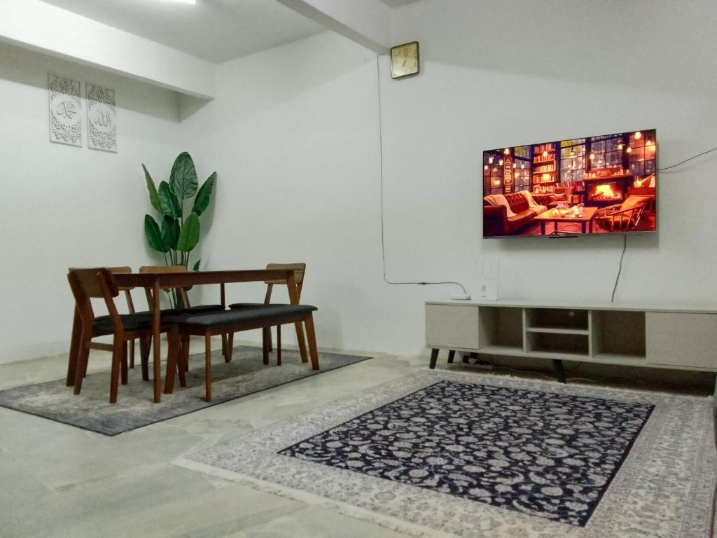 MGH Homestay Bangi Wonderland في كاجانغ: غرفة معيشة مع طاولة وتلفزيون على الحائط