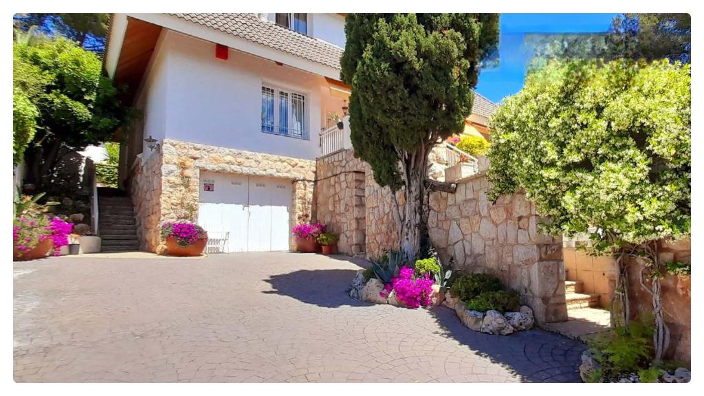 a house with a driveway with a garage at Chalet acogedor en La Mora in Tarragona