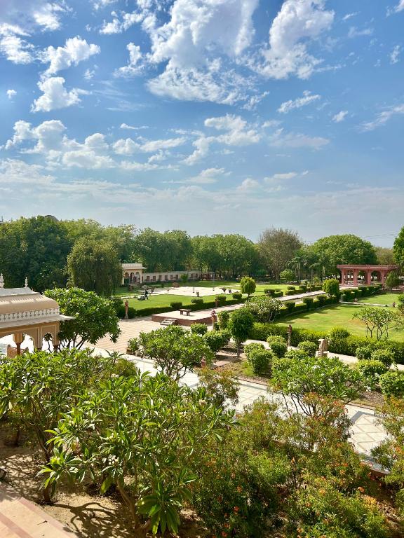 DubbīUmaid Palace - A Lakeside Resort - 25 minutes from Mehandipur Balaji - 20 minutes from Chand Baori Stepwell Abhaneri & 40 minutes from Bhangarh Fort的享有树木和建筑花园的景色