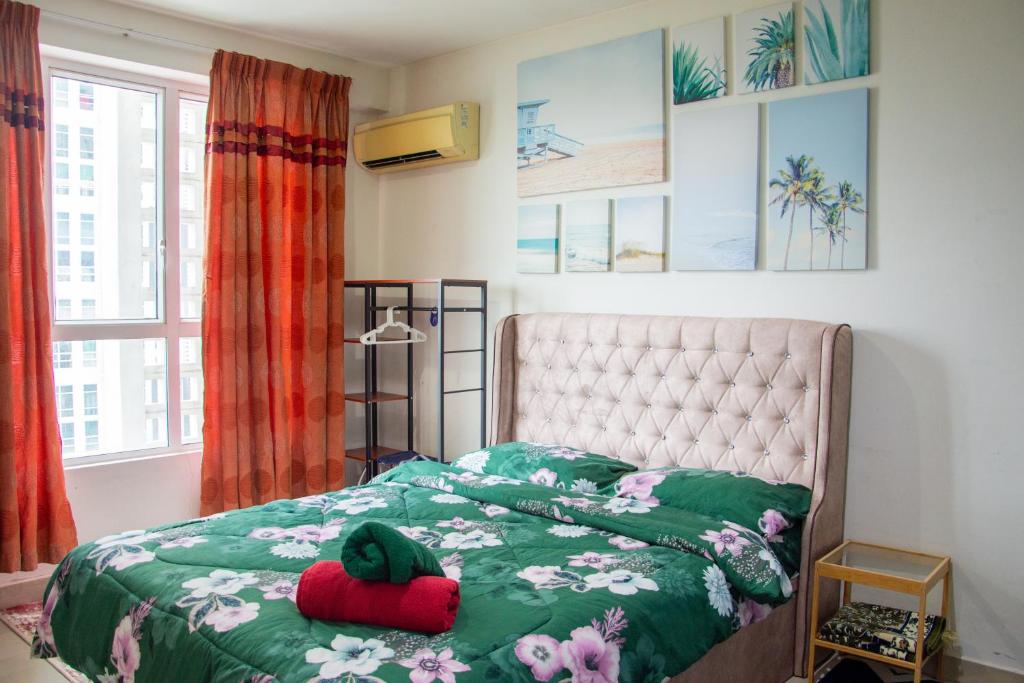 1 dormitorio con 1 cama con edredón verde en Homestay at Menara U en Shah Alam