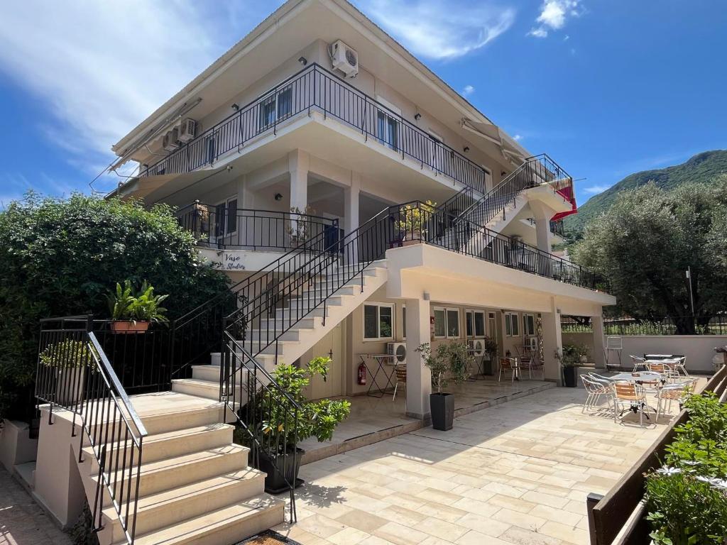 une grande maison blanche avec des escaliers et une terrasse. dans l'établissement Vaso Studios, à Vathi