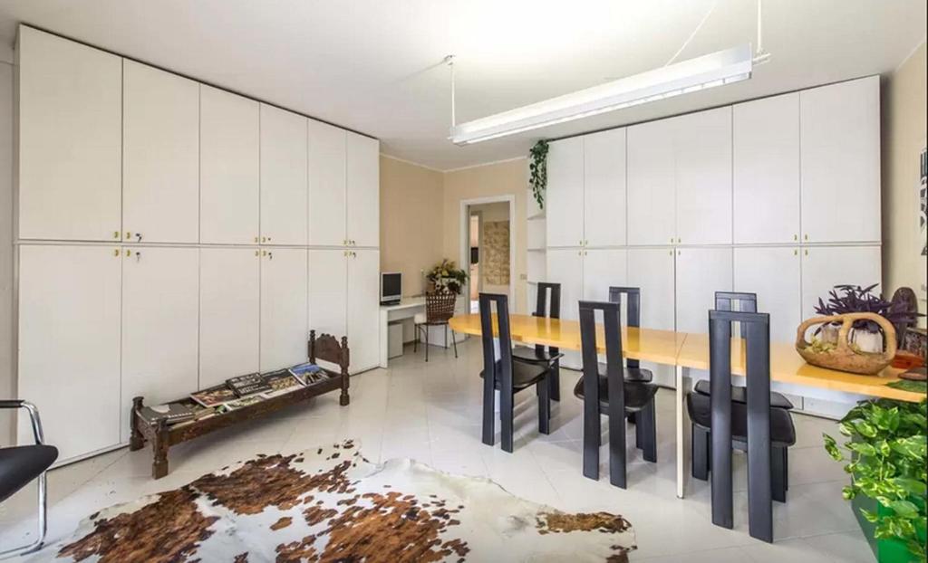 a dining room with white cabinets and a table and chairs at B&B La Villa in Seriate