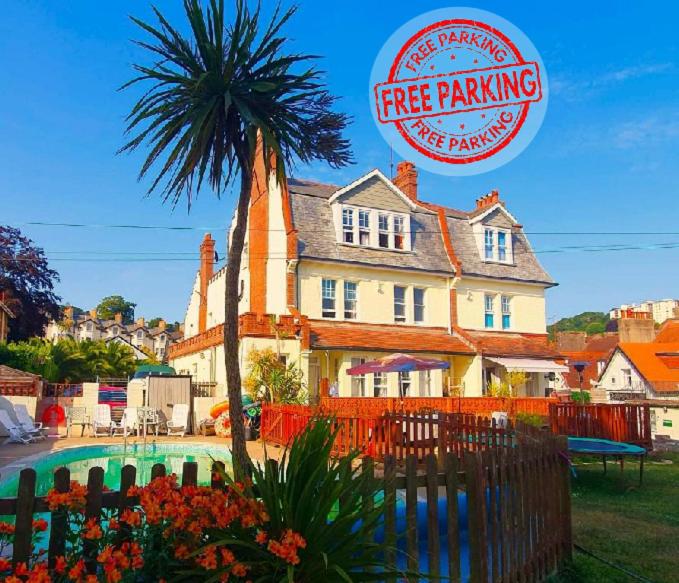 a free parking sign and a palm tree in front of a building at Yardley Manor Hotel in Torquay
