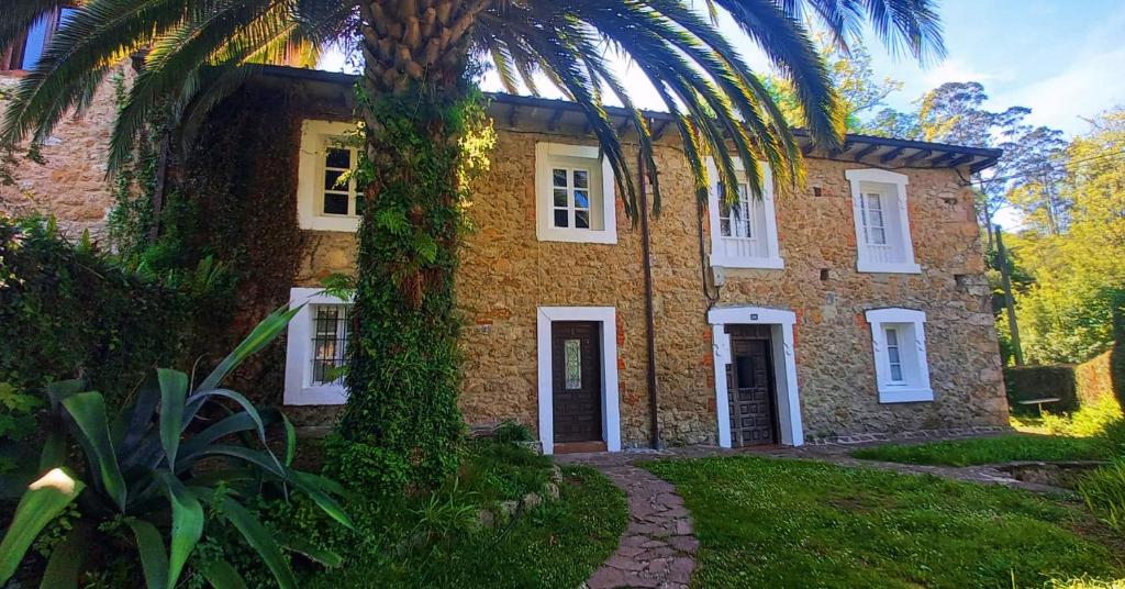 une maison en briques avec un palmier en face de celle-ci dans l'établissement Posada -Meson la gándara, 